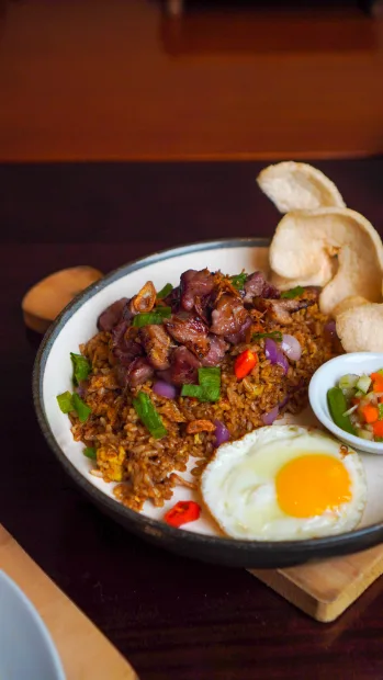 Rice bowl with egg and beef on a dark table