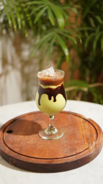 Layered iced dessert drink on a wooden board